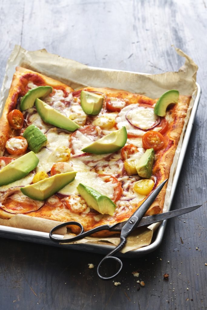 Pizza med mozzarella, tomat och avocado.