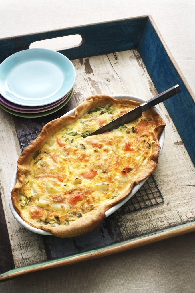 Laxpaj serverat i ugnsform på bricka med blå tallrikar