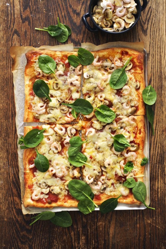 Pizza med vitlöksmarinerade räkor, färska champinjoner och spenat
