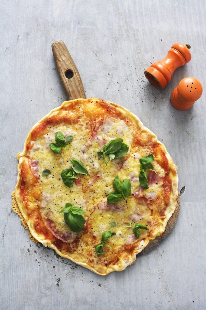Pizza med skinka och basilika