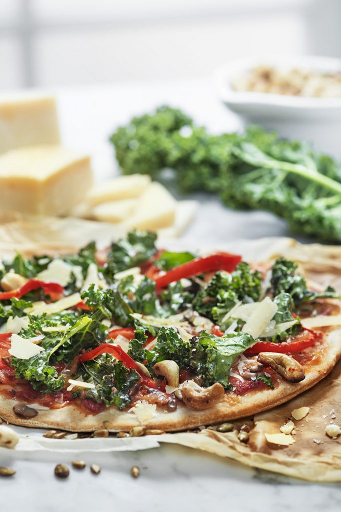 Tunn pizza med grönsaker, grönkål och nötter, hälsosamt vegetariskt alternativ, från Pop Bakery.