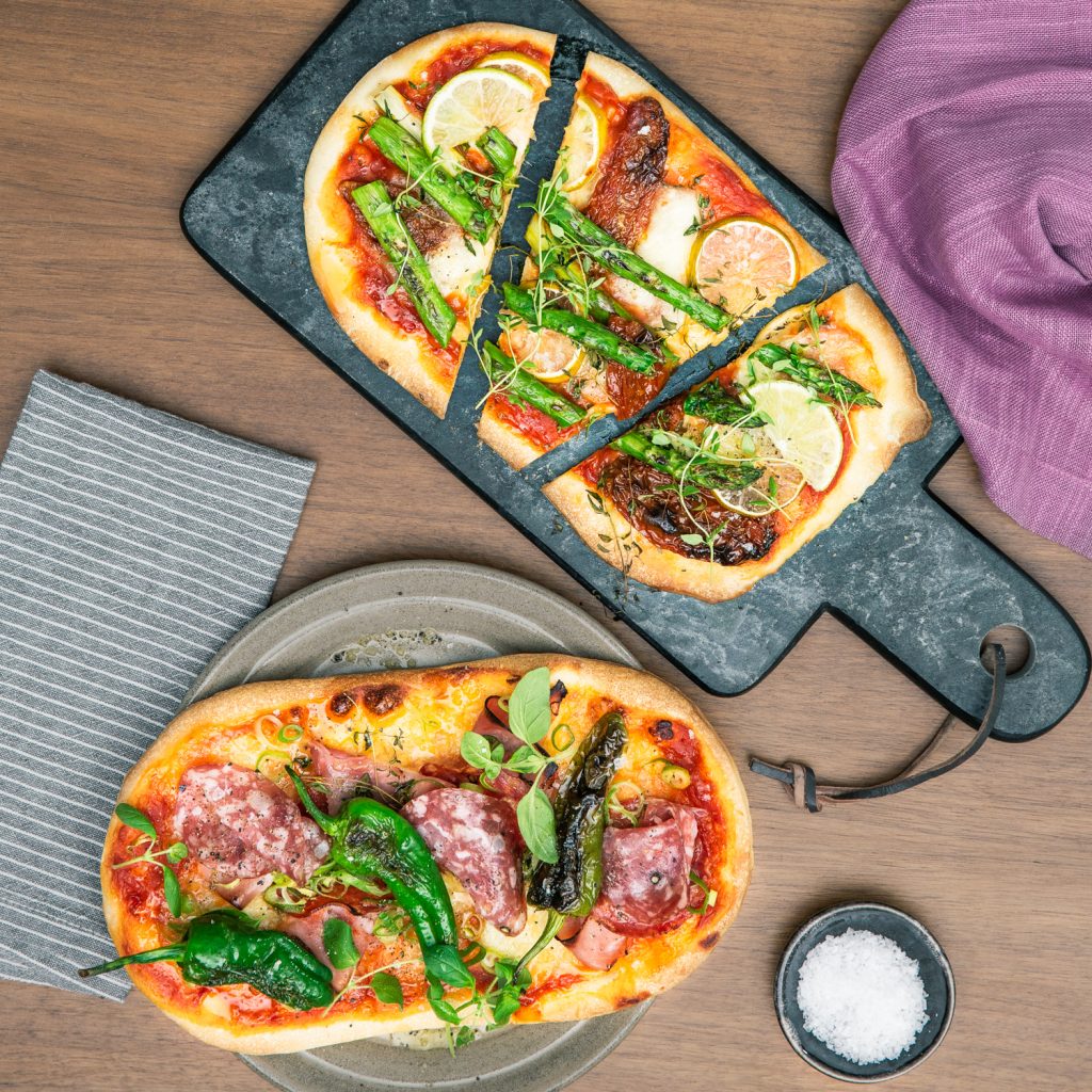Färsk pizza med grönsaker, örter och charkuterier från Pop Bakery.