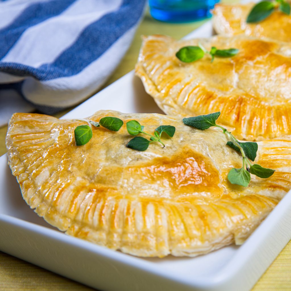 Två tillagade empanadas med örtkryddor.
