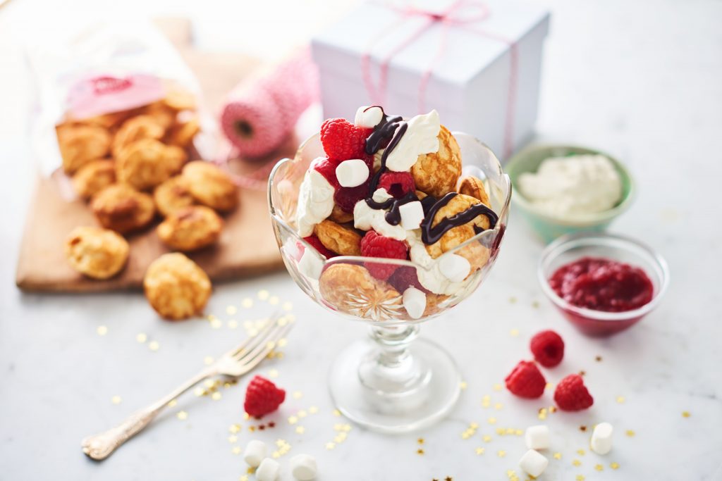 Vacker skål med mumspannkakor, bär och grädde.