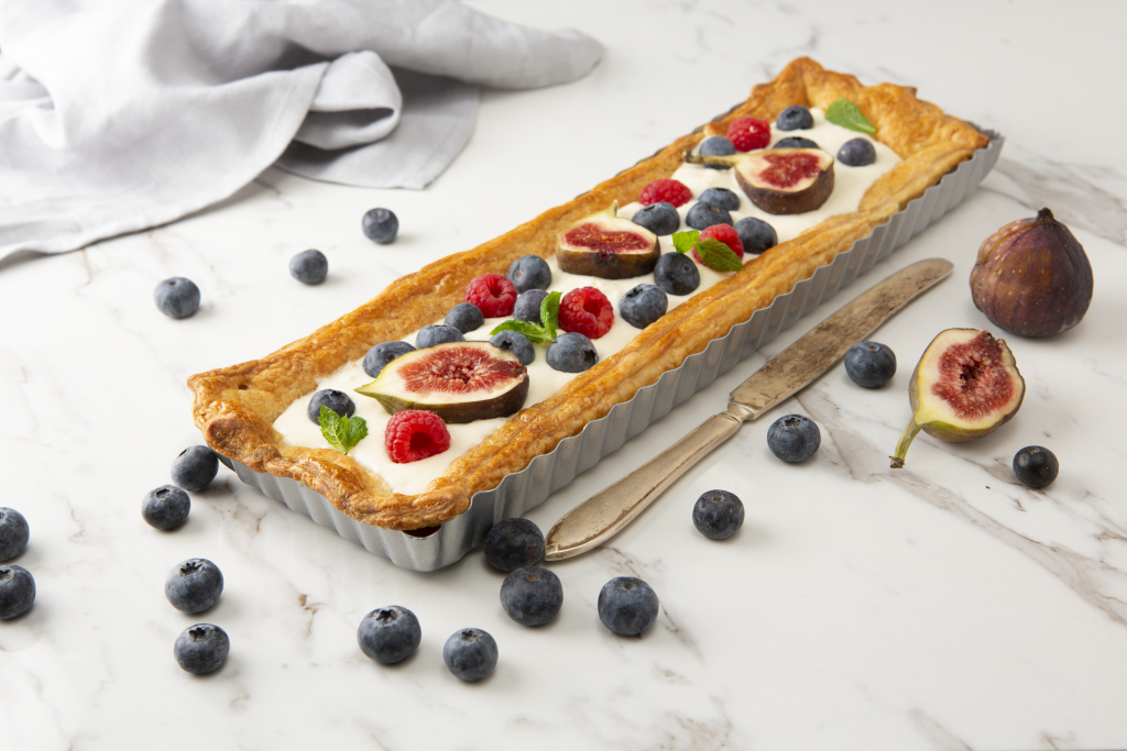 En långsmal smördegspaj garnerad med härliga bär